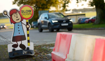 Car driving past slow down sign