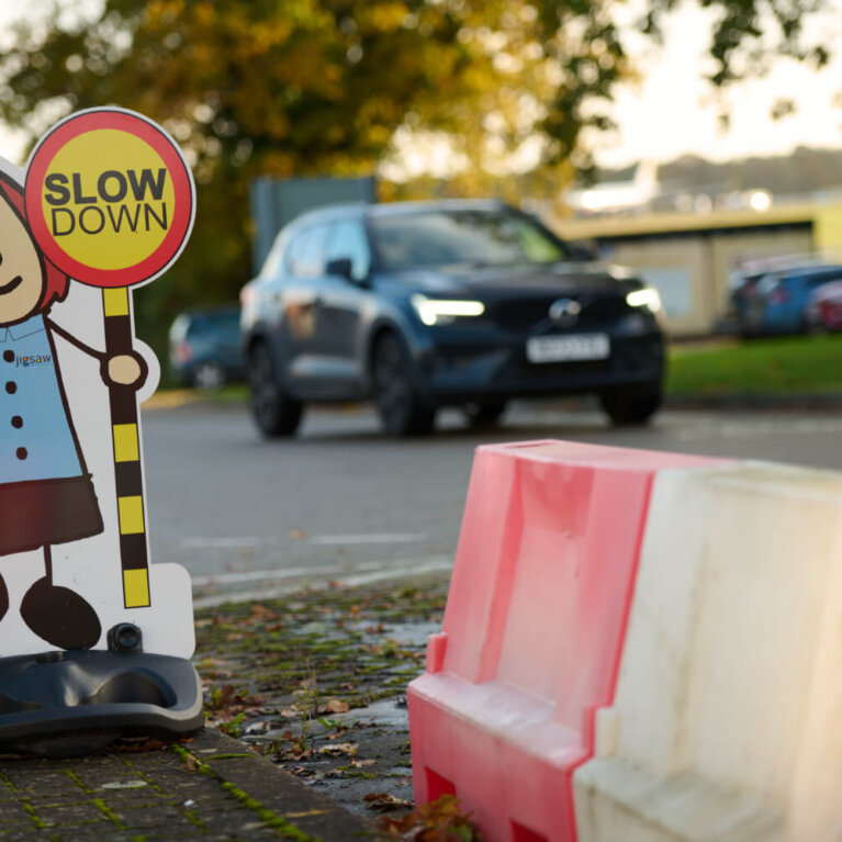 Car driving past slow down sign